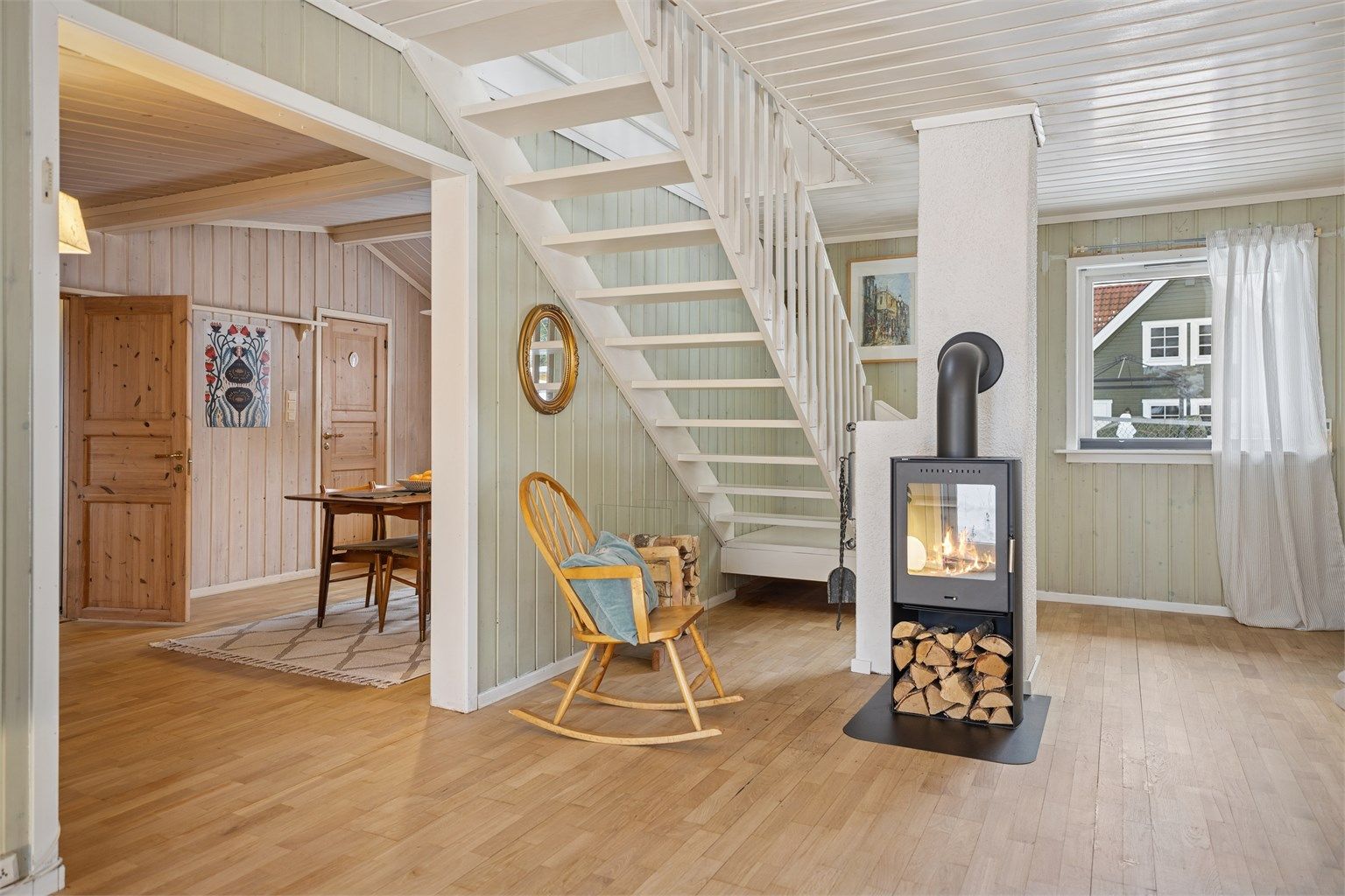 Det hvitmalte tretaket løfter romfølelsen ytterligere. Fra stua er det trapp opp til loftetasjen.