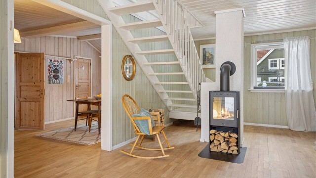 Det hvitmalte tretaket løfter romfølelsen ytterligere. Fra stua er det trapp opp til loftetasjen.