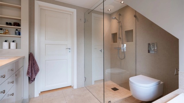 Den romslige dusjsonen med innfellbare glassdører gir badet et stilrent og åpent uttrykk.