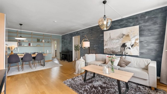 Den romslige stuen har plass til både sofagruppe og en egen spisedel.