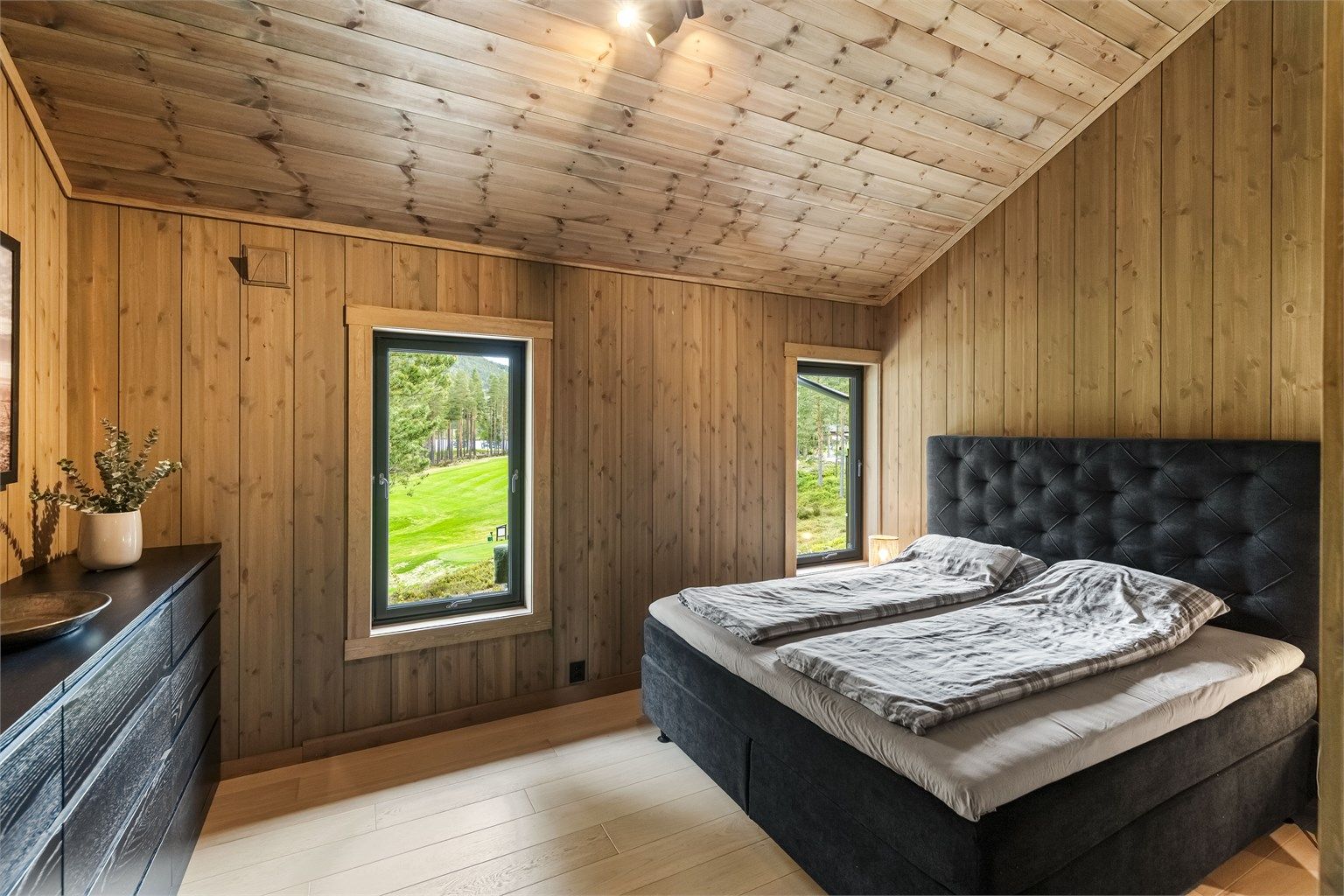 Hovedsoverom med parkett på gulv og panel på vegger og i himling.