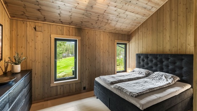 Hovedsoverom med parkett på gulv og panel på vegger og i himling.