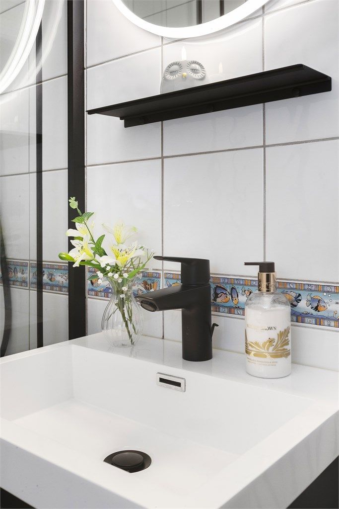 Detaljer fra badet, med vegghengt servantinnredning og ett-greps armatur.
