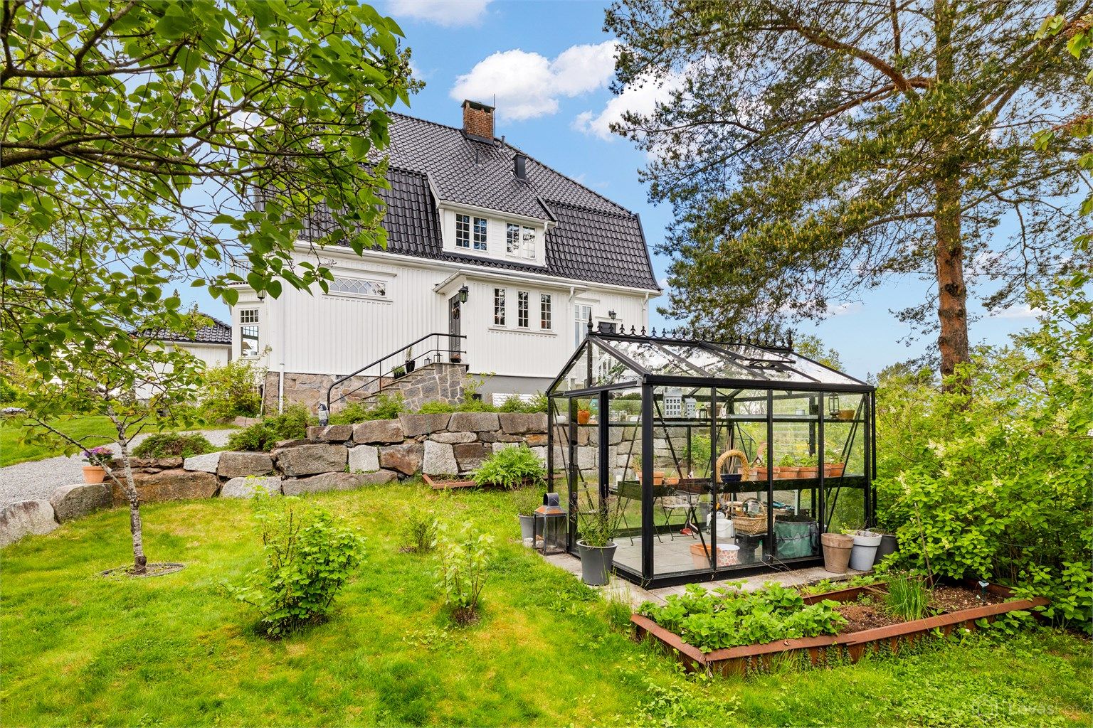 Flott opparbeidet hage med bl.a. drivhus