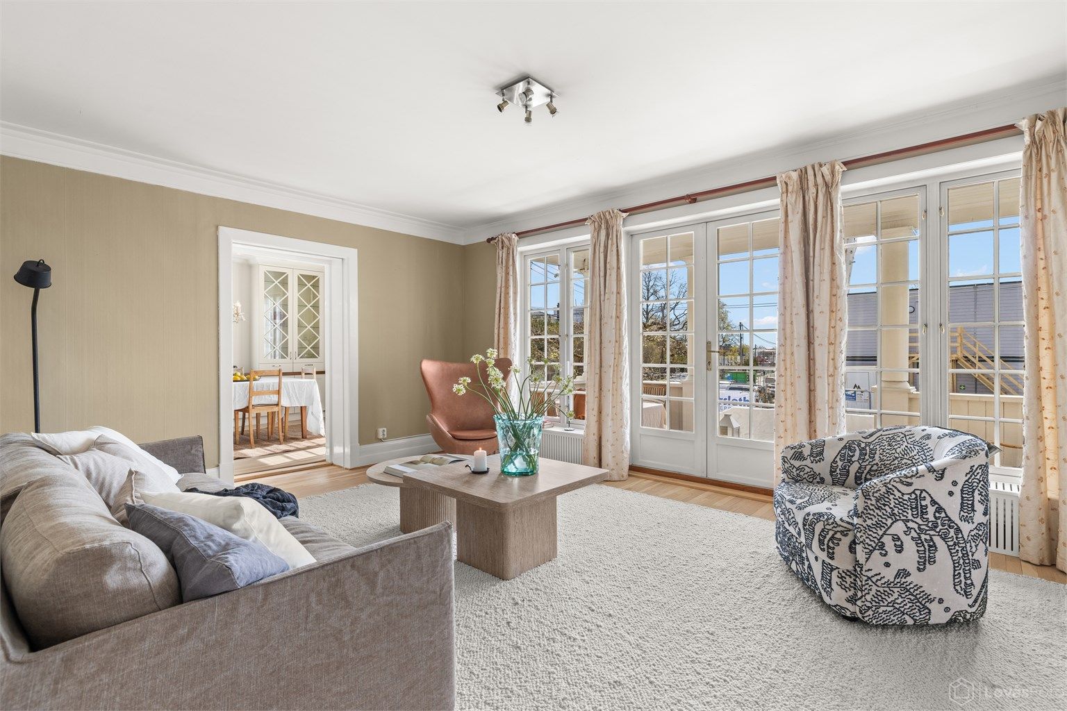 Store sprossede glassflater mot terrassen som gir god god kontakt mellom inne- og uterom