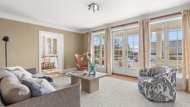 Store sprossede glassflater mot terrassen som gir god god kontakt mellom inne- og uterom