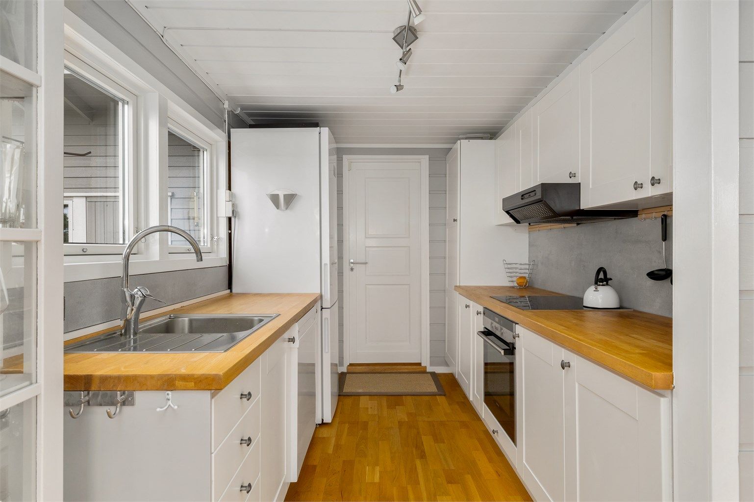 GOD ARBEIDSPLASS: Kjøkkeninnredning på begge sider i rommet og utgang direkte til terrassen.