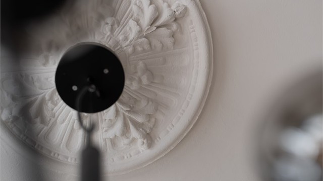 Nydelige, klassiske detaljer som rosett og stukkatur går igjen i leiligheten.