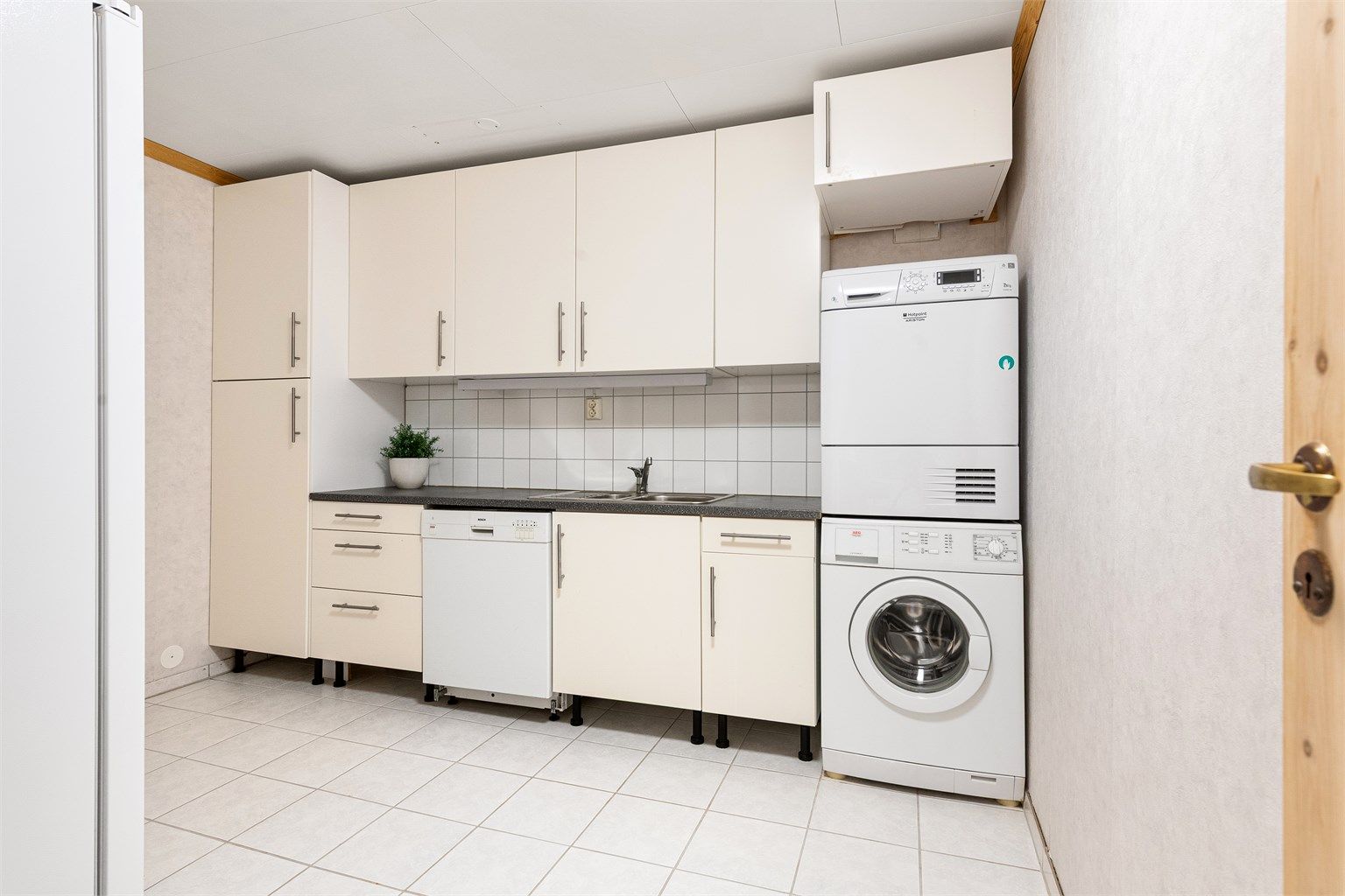 Vaskerommet er fra ca. 2001 og har flislagt gulv med gulvvarme. Innredning fra ca. 2009 med glatte hvite fronter og laminat benkeplate med nedfelt skyllekum og flisplater på vegg over benken. Opplegg for vaskemaskin, tørketrommel og oppvaskmaskin. 