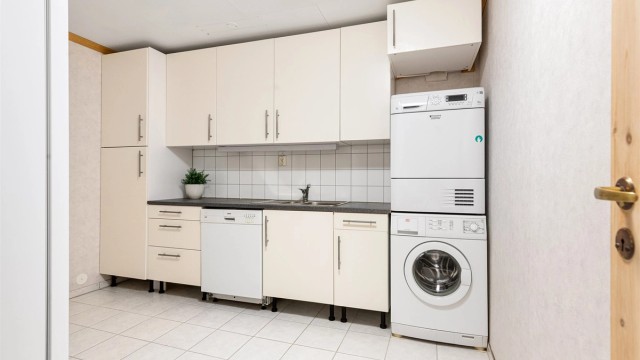 Vaskerommet er fra ca. 2001 og har flislagt gulv med gulvvarme. Innredning fra ca. 2009 med glatte hvite fronter og laminat benkeplate med nedfelt skyllekum og flisplater på vegg over benken. Opplegg for vaskemaskin, tørketrommel og oppvaskmaskin.