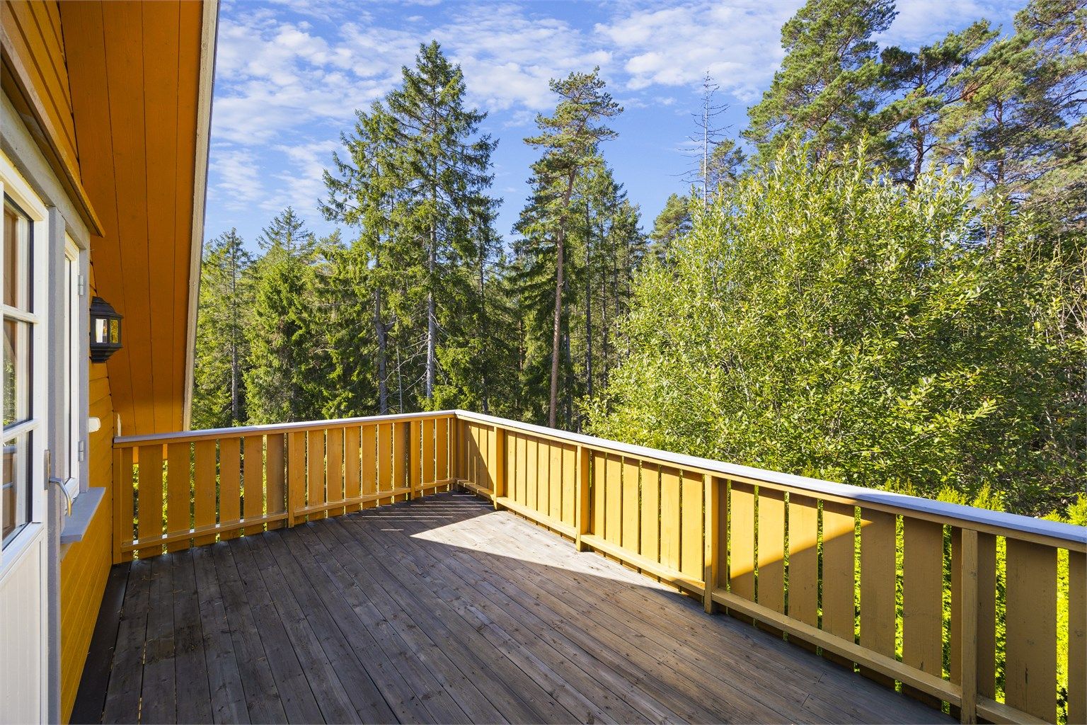 Stor luftebalkong med lite innsyn og tilgang fra hovedsoverommet.