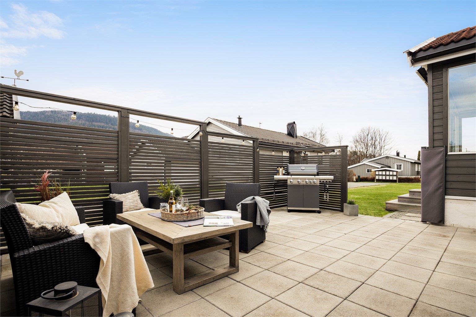 Hyggelig og skjermet hellelagt uteplass som egner seg godt for sosiale sammenkomster. Foto: Stine Prøitz Jørgensen