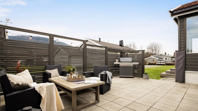 Hyggelig og skjermet hellelagt uteplass som egner seg godt for sosiale sammenkomster. Foto: Stine Prøitz Jørgensen