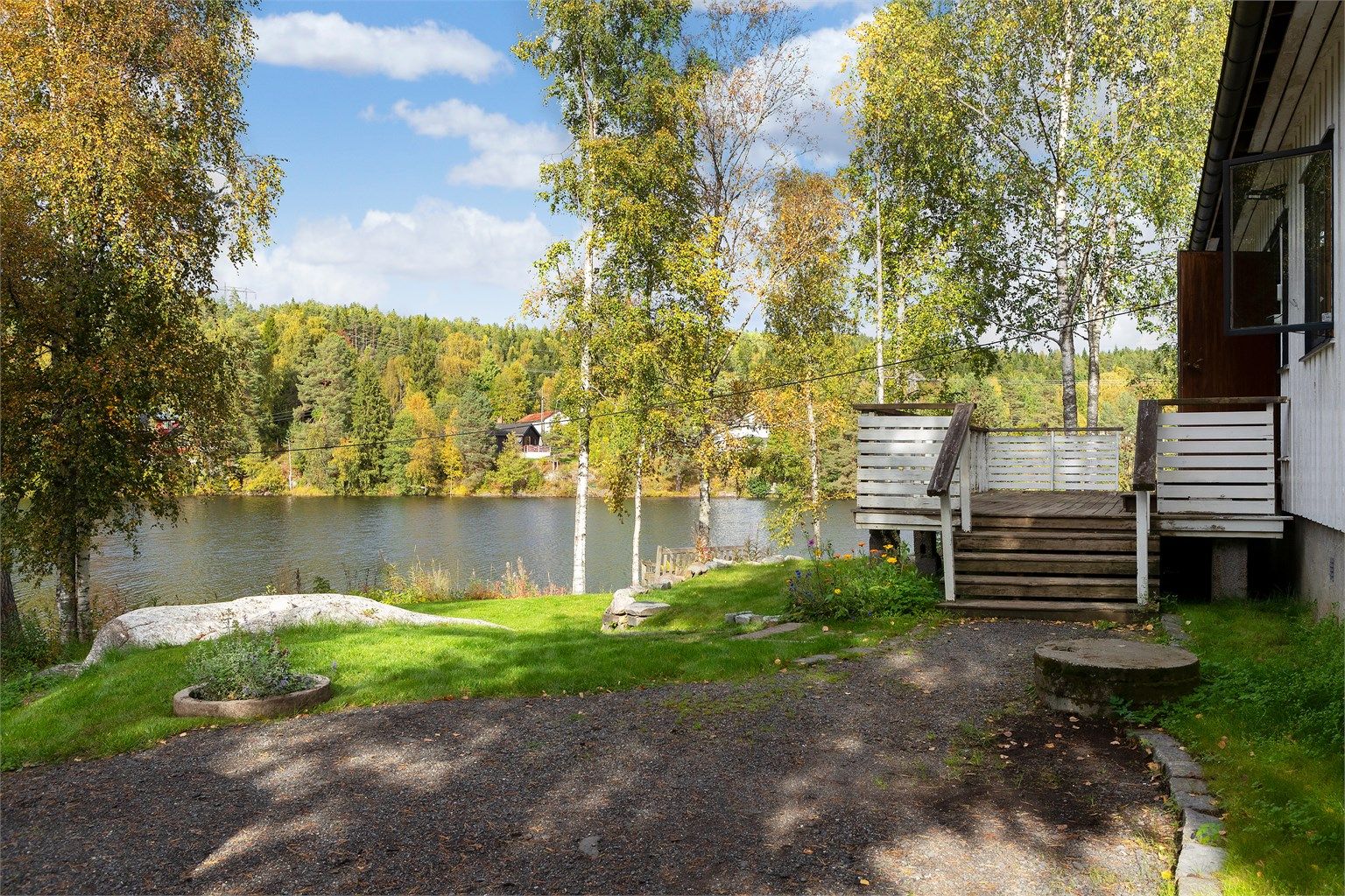 Trapper i treverk leder opp til terrassen og videre inn i boligen.
