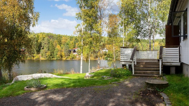 Trapper i treverk leder opp til terrassen og videre inn i boligen.