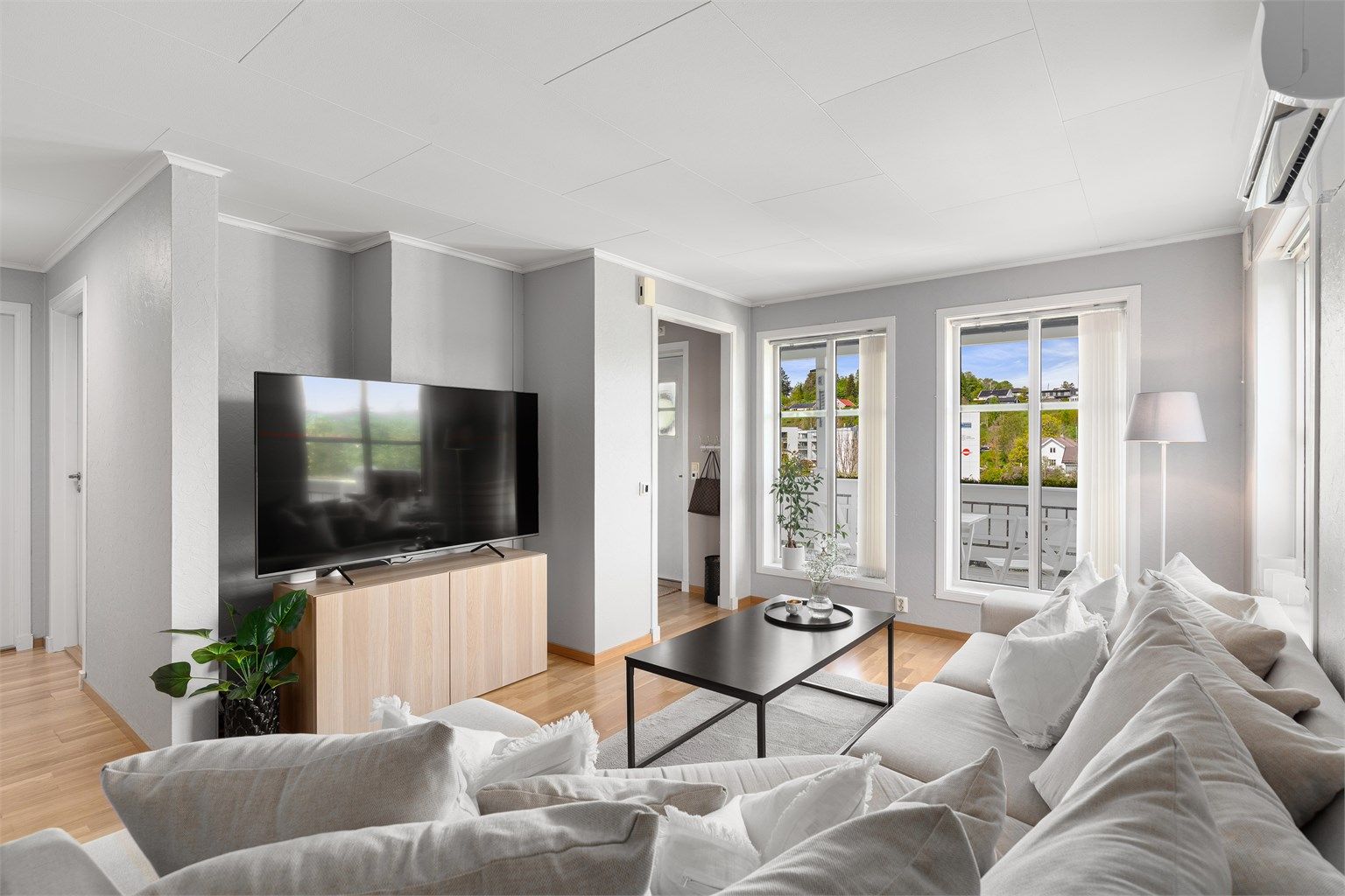 Romslig stue med plass til sofaløsning og tv-seksjon. Store vindusflater som slipper inn rikelig med naturlig lys