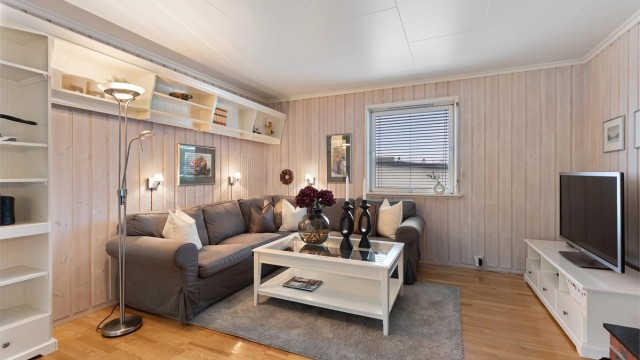 Plassbygde hyller gir smart oppbevaring og en fin ramme rundt sofakroken.