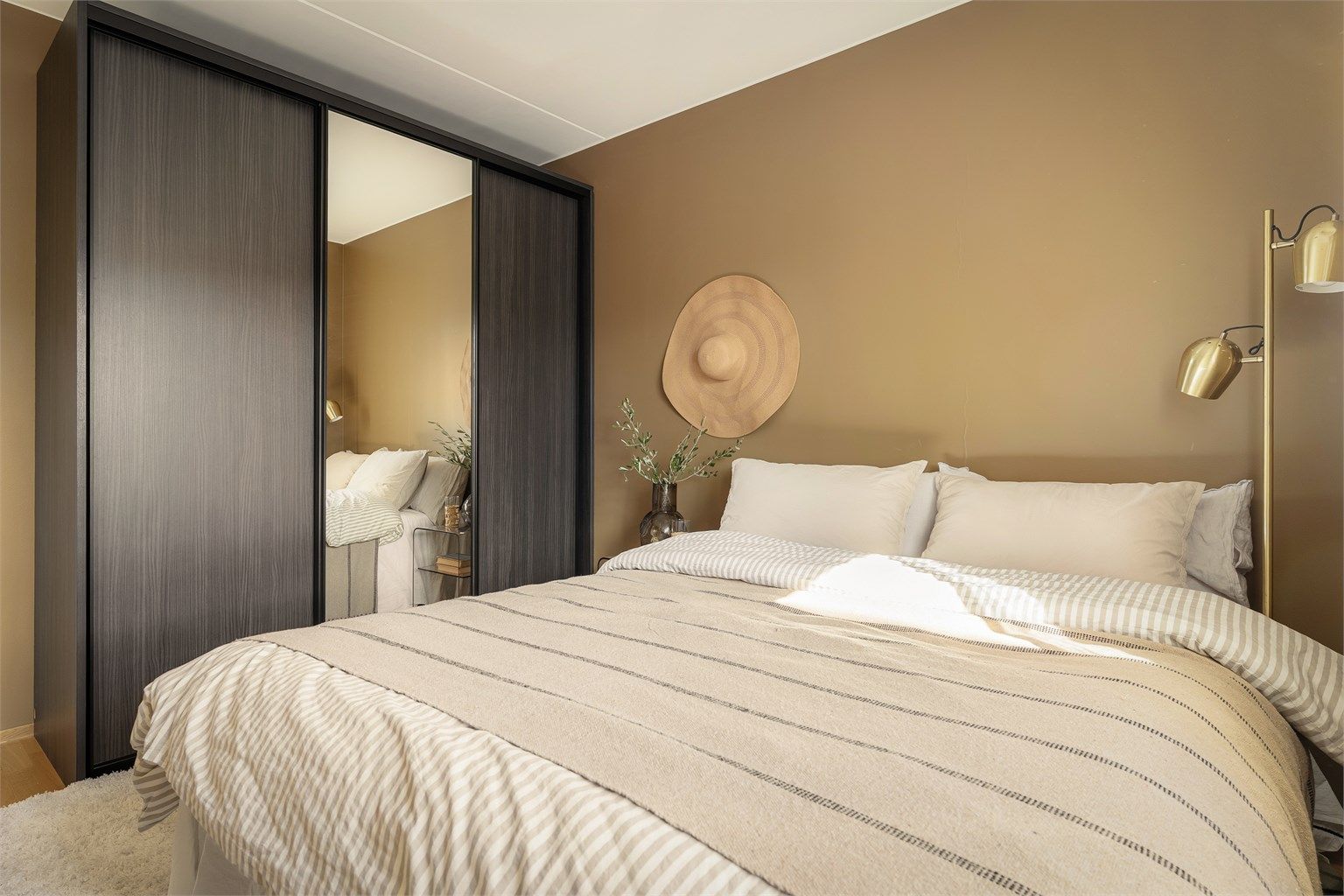 En romslig skyvedørsgarderobe med speilfronter gir rikelig med oppbevaringsplass på soverommet.