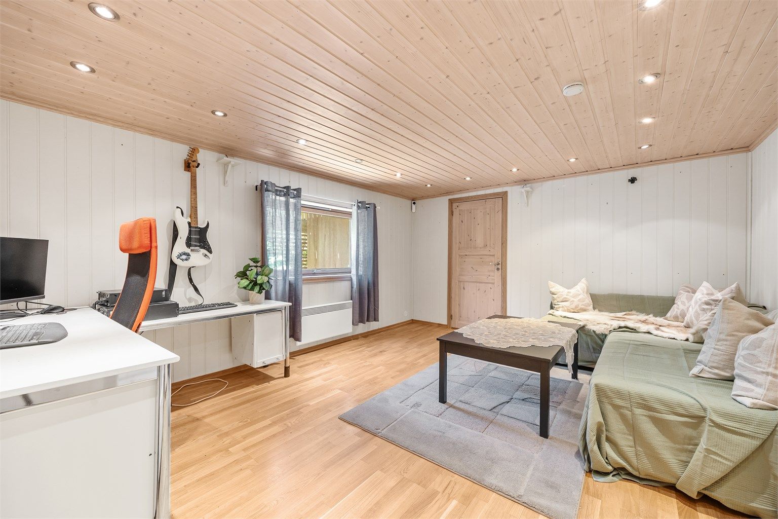 Kjellerstue med panel på vegger og i tak. Takhøyden i rommet er målt til ca. 2,02 meter.