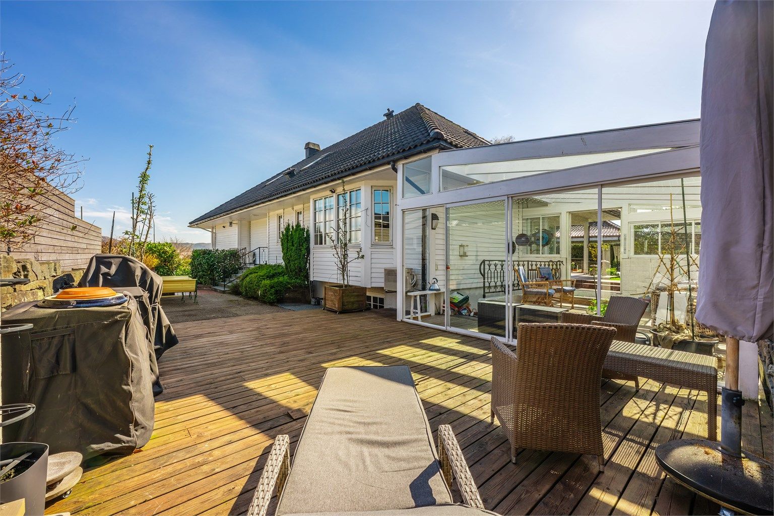 Terrasse rundt store deler av boligen i tillegg til hage og "glasshus".