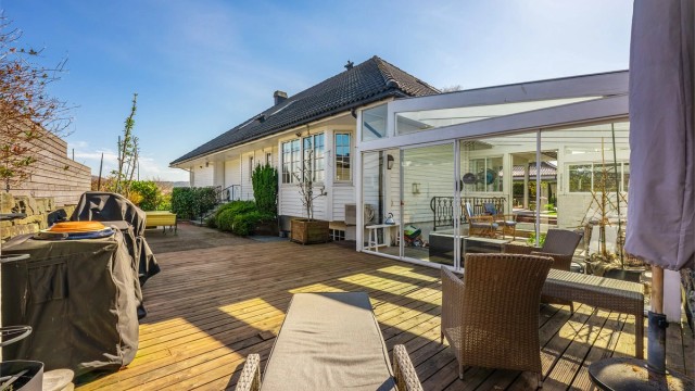 Terrasse rundt store deler av boligen i tillegg til hage og "glasshus".