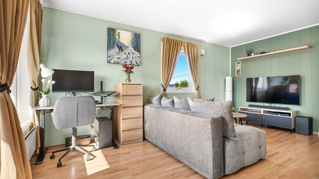 Rommet gir fleksibilitet for møblering, med plass til både sofagruppe og en egen kontorløsning. Takhøyden er målt til ca. 2,4 meter.