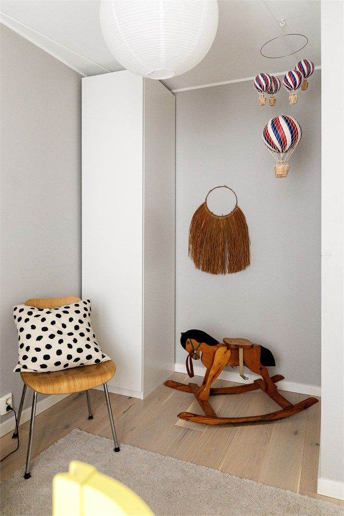 Rommets veggflater er malt i en lys farge med påmalte "fjelltopper" og samme, lyse eikeparkett som i resten av boligen