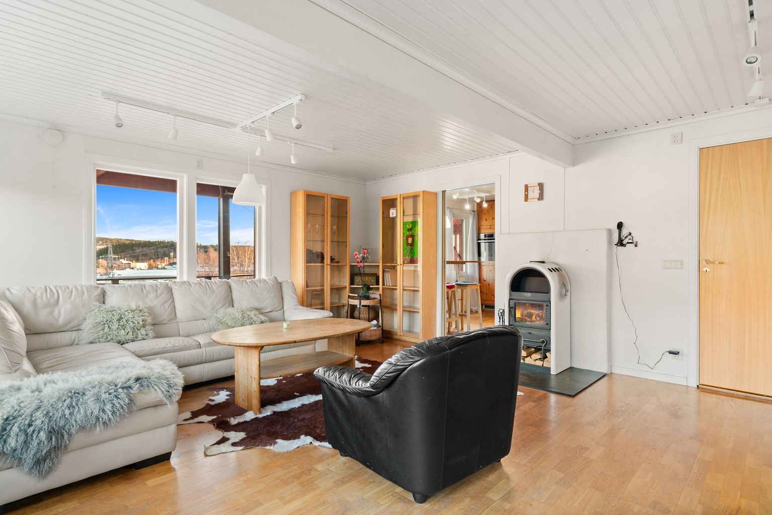  I stuen er det også en herlig peisovn - perfekt for kalde vinterkvelder. Store vindusflater sørger for rikelig med lysinnslipp, og skaper en lys og luftig atmosfære.