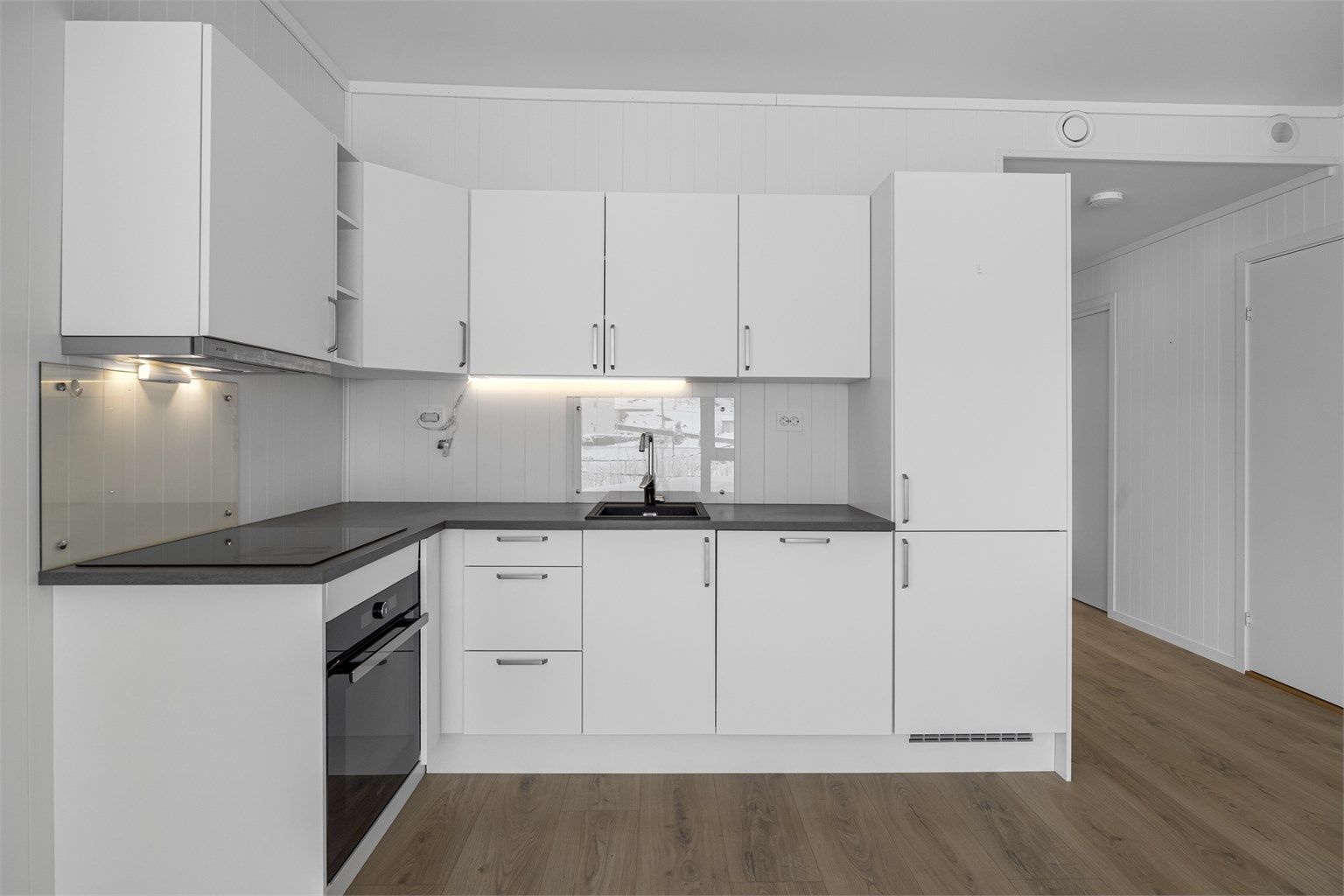 Kjøkken med komfyrvakt og glassplate på utsatte steder.