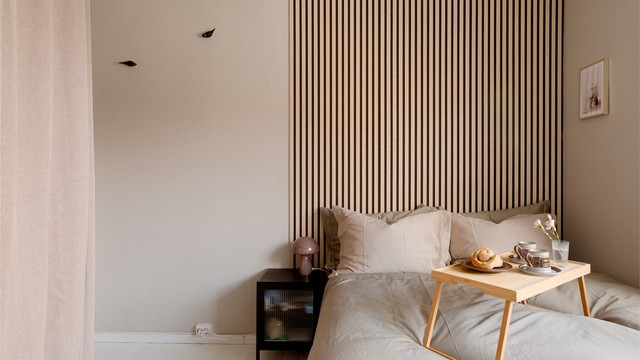 Rommet har malte tregulv og en gavlvegg med materialer som spiller på lag med miljøet rundt. Organisk og vakkert!