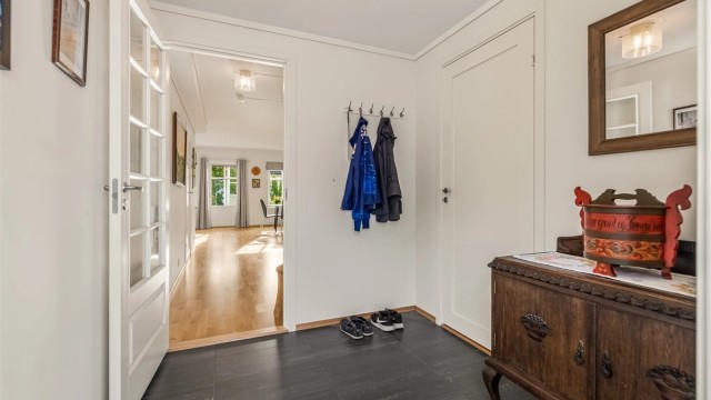 Entré med flis med varmekabler på gulvet og plass til klesoppheng.