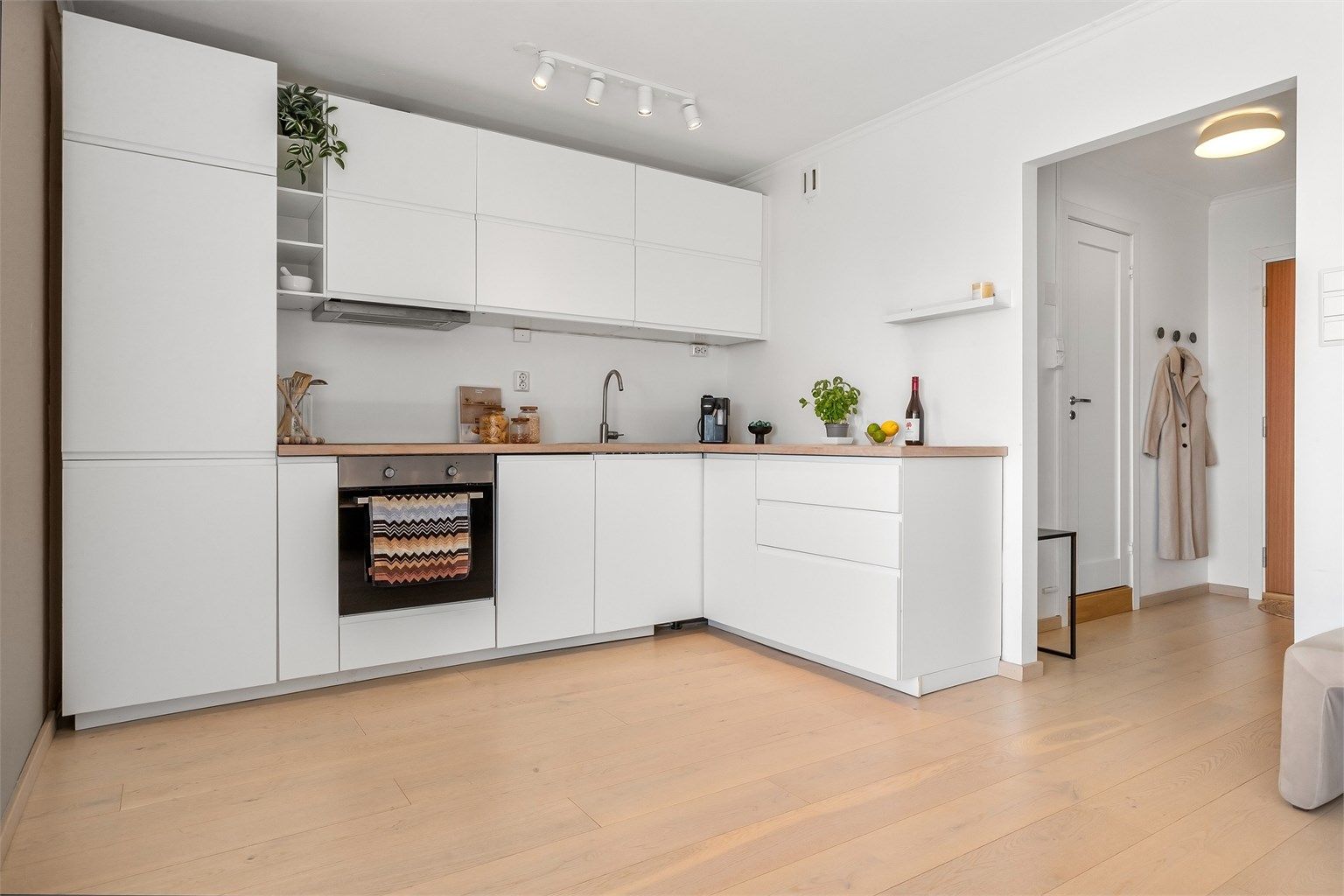 Moderne kjøkken fra 2017 med glatte fronter og benkeplate i tre. Kjøkken har en åpen løsning mot stuen