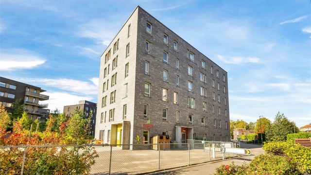 Moderne boligbygg fra 2013 med teglfasade og barnehage etablert i første etasje.