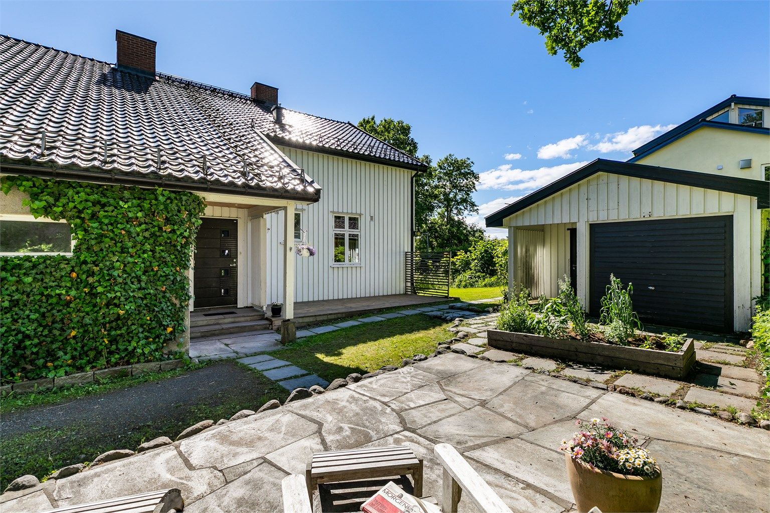 Ny platting ble anlagt foran inngangspartiet med le for sønnavind og sol hele hagen.