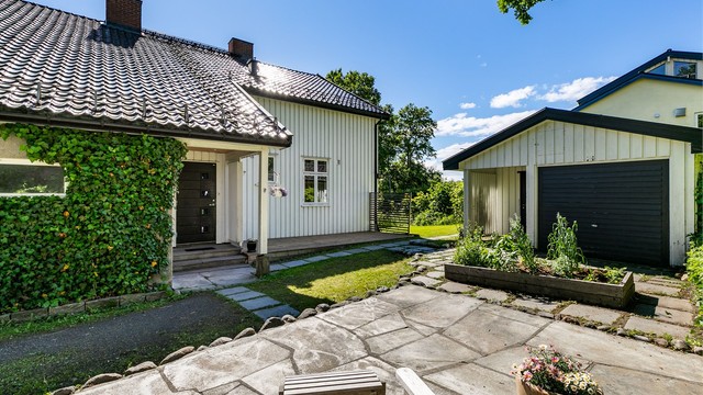 Ny platting ble anlagt foran inngangspartiet med le for sønnavind og sol hele hagen.