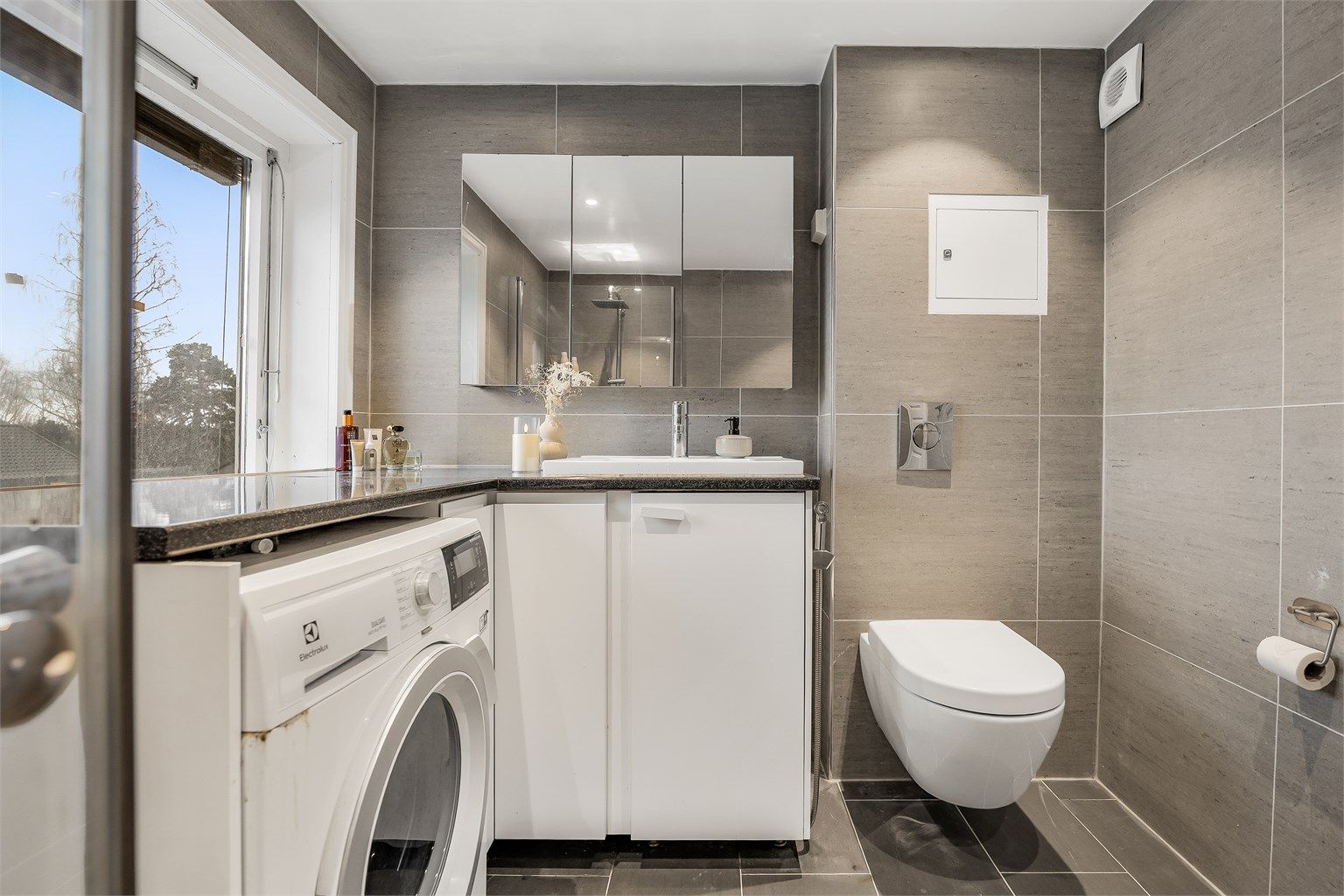 Vegghengt servantinnredning og speilskap gir god oppbevaring.