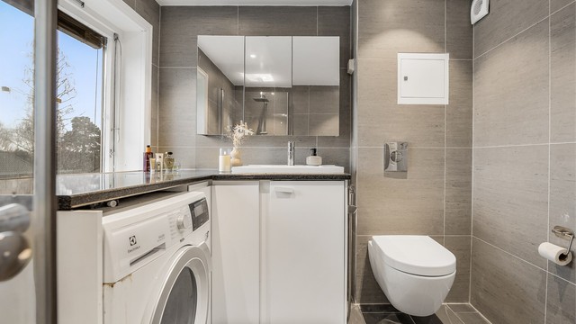 Vegghengt servantinnredning og speilskap gir god oppbevaring.