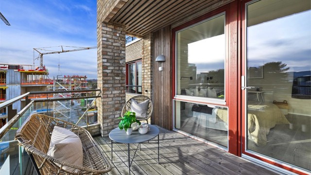 Gulvflatene er belagt med terrassebord og rekkverket er av metall og glass. Her er også utebelysning