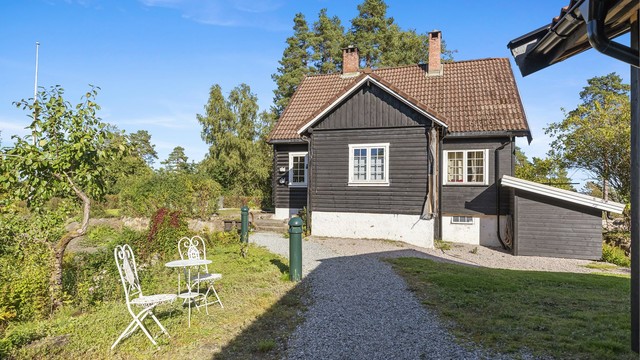 Eiendommen er pent opparbeidet med gressplen, trær, prydbusker og diverse beplantning.