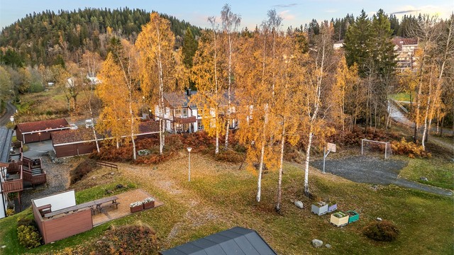 Pent opparbeidet fellesarealer med ballbane, huskestativ og platting med flere sittebenker samt levegger.