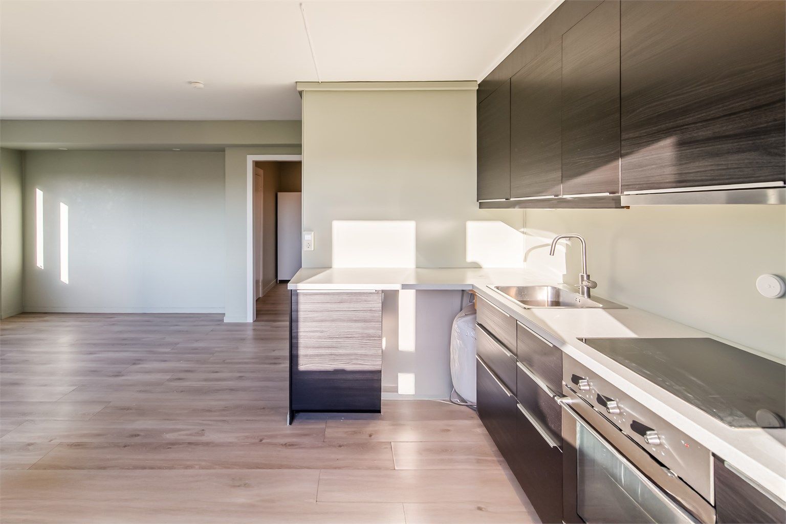 Kjøkkenet har godt med både skap og benkplass og innredning er i slett og dempet utførelse