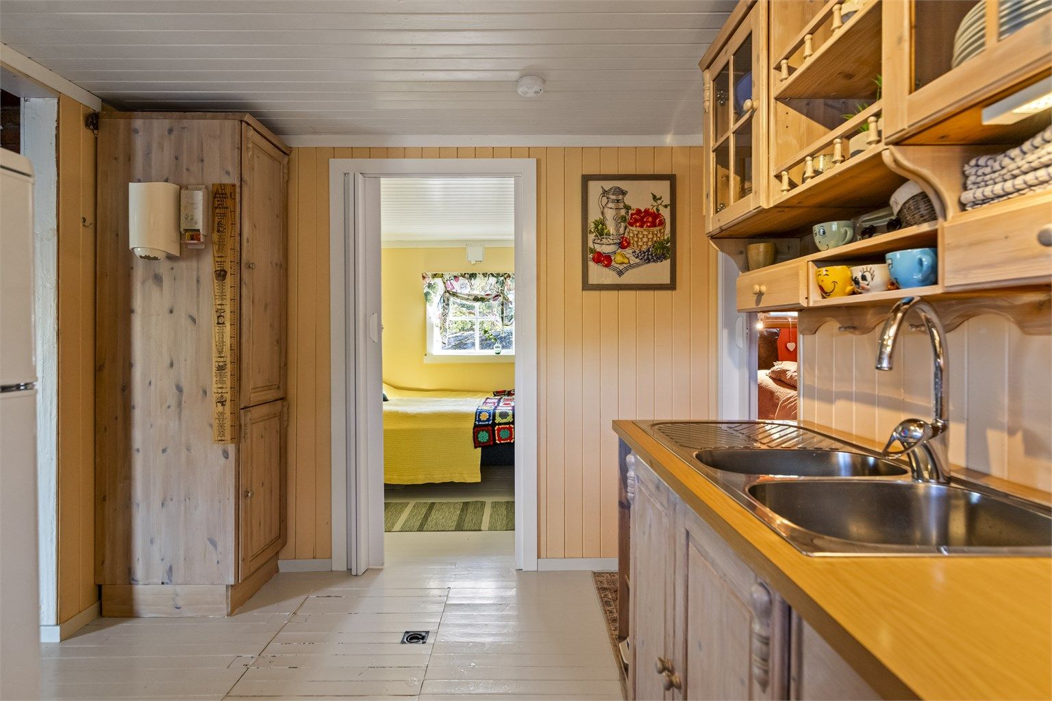 En praktisk luke i kjøkkengulvet gir tilgang til ekstra oppbevaringsplass under hytta.