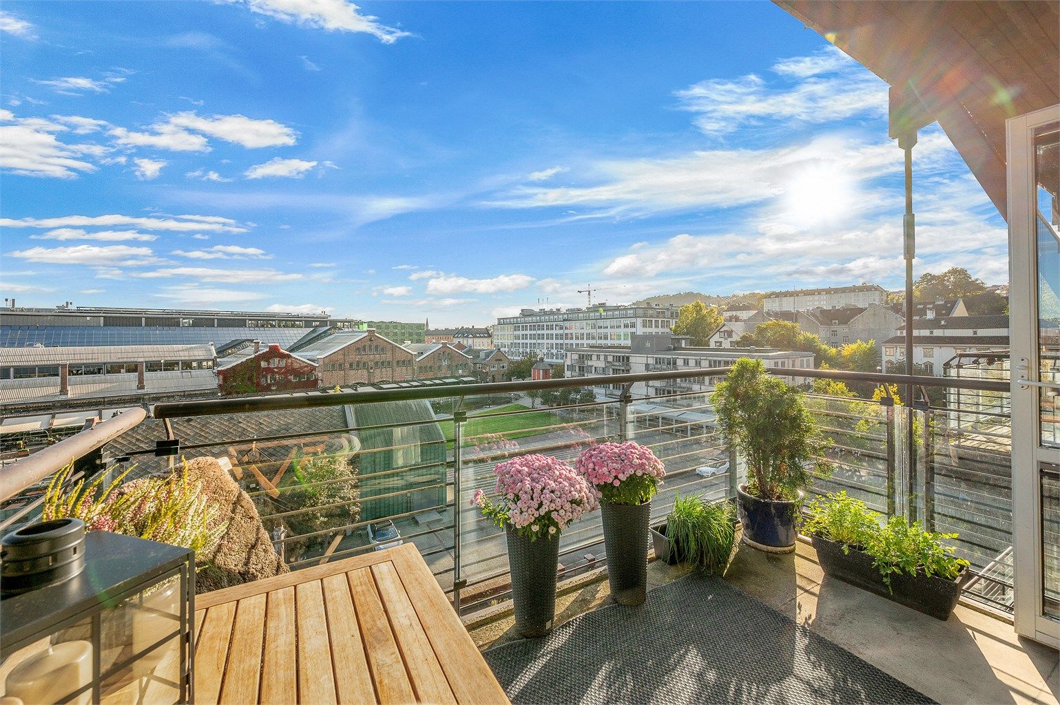 Balkongen har rekkverk i metall og glass, og har plass til sittegruppe og beplantning.