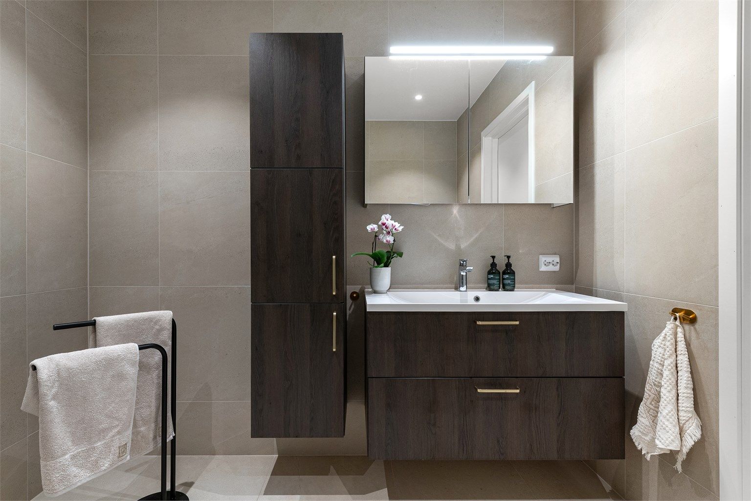 Baderomsinnredningen består av servantskap, speilskap med belysning og et praktisk, vegghengt høyskap