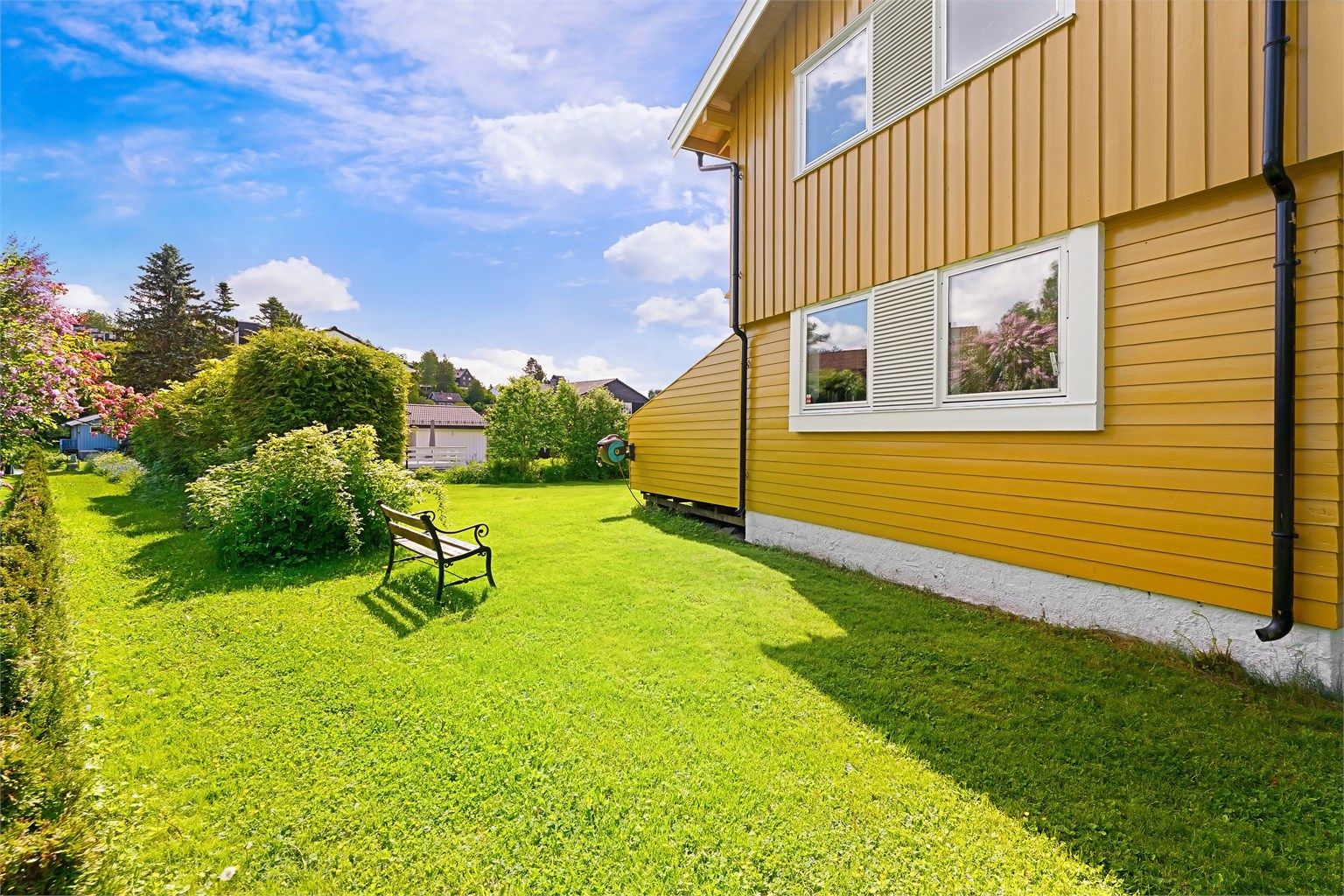 Tomten er opparbeidet med plenarealer og diverse beplantning.