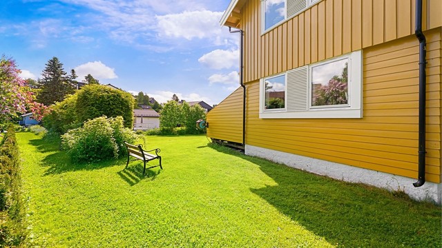 Tomten er opparbeidet med plenarealer og diverse beplantning.