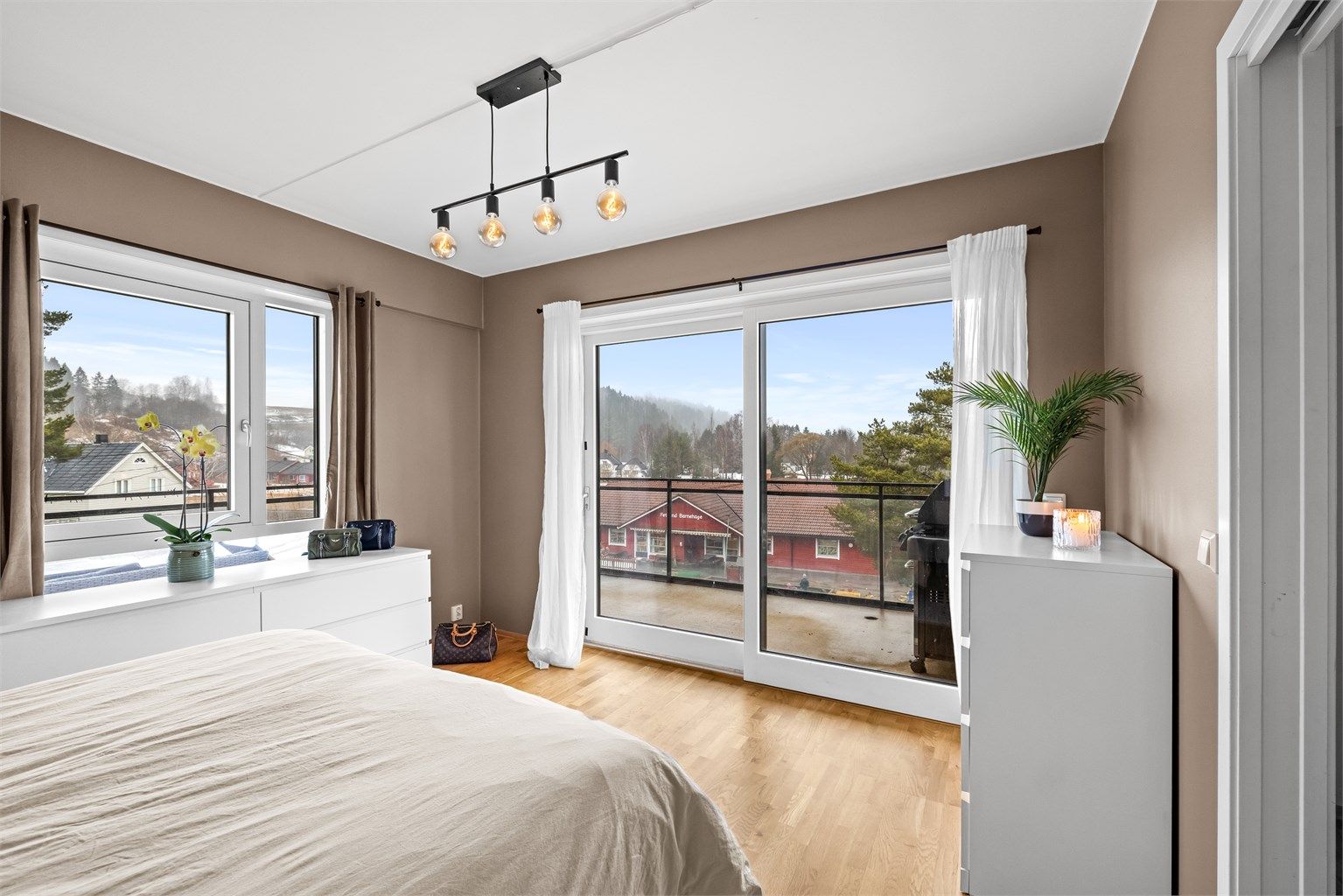 En bred skyvedør i glass fra byggeåret åpner opp mot den store balkongen.