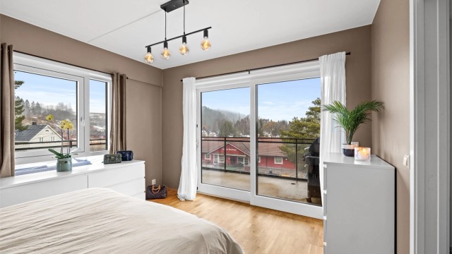 En bred skyvedør i glass fra byggeåret åpner opp mot den store balkongen.