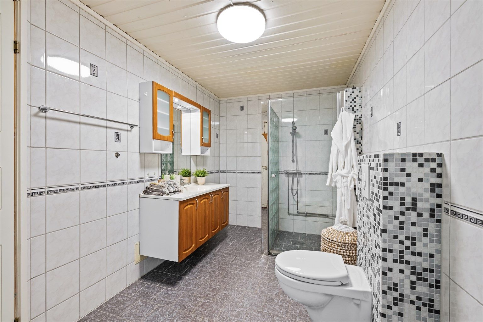 Romslig, flislagt bad med varmekabler i gulvet for økt komfort.