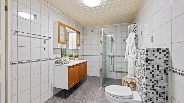 Romslig, flislagt bad med varmekabler i gulvet for økt komfort.